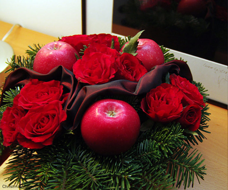 Finished arrangement with Pink Lady apples, red roses, pine twigs, and a luxurious red ribbon.