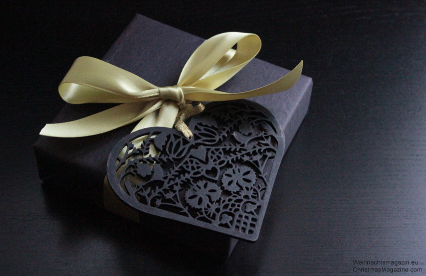 present wrapped in black decorated with Scherenschnitt ornament