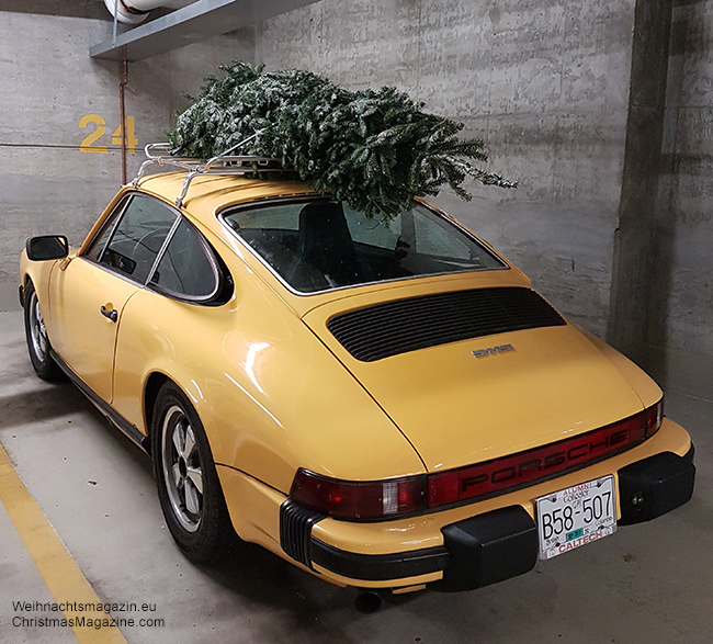 vintage yellow Porsche with Christmas tree on roof