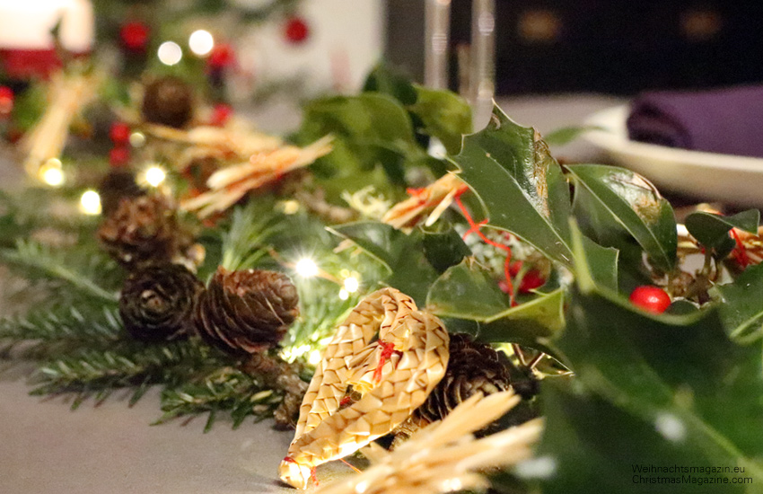 holly, straw stars, pinecones, traditional German Christmas table, rustic