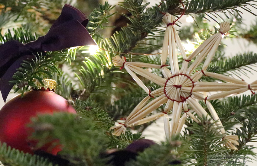 straw stars, decorated Christmas tree, purple satin bow