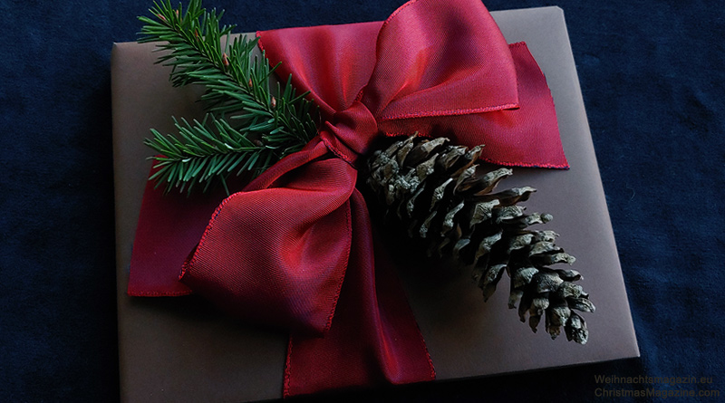 gift wrapped in brown paper, ruby bow, pinecone