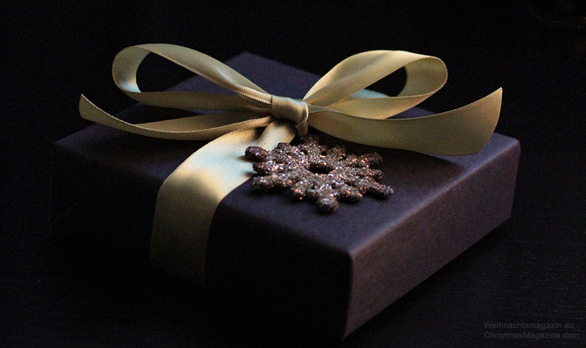 present wrapped in black, ribbon, glitter snowflake