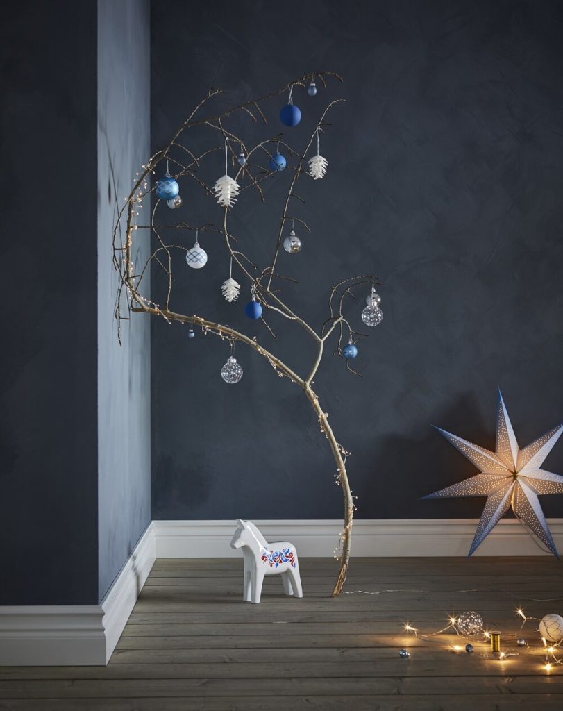 tree branch decorated with baubles, blue, white, fairy lights