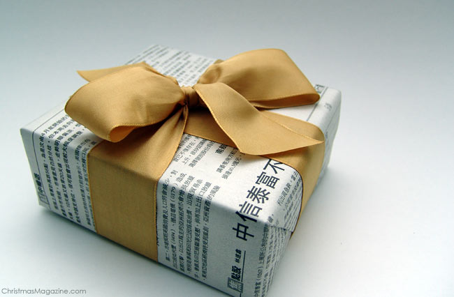 Christmas gift wrapped in newspaper, gold ribbon
